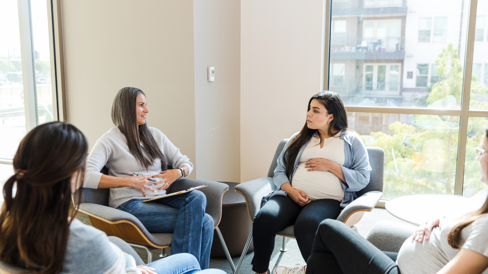Dos mujeres conversando con calma, una de ellas embarazada