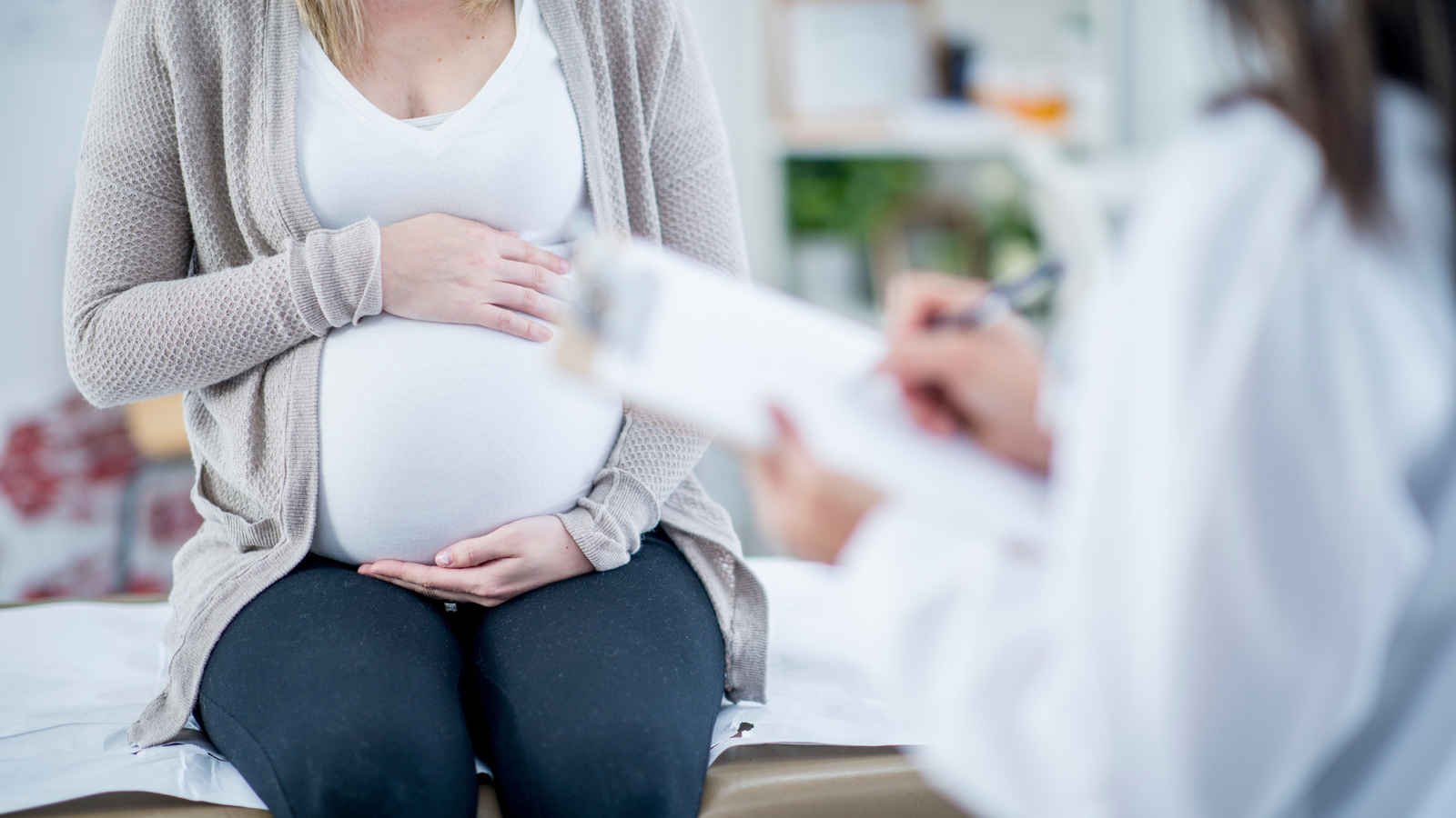 Mujer embarazada en una consulta con una profesional de la salud