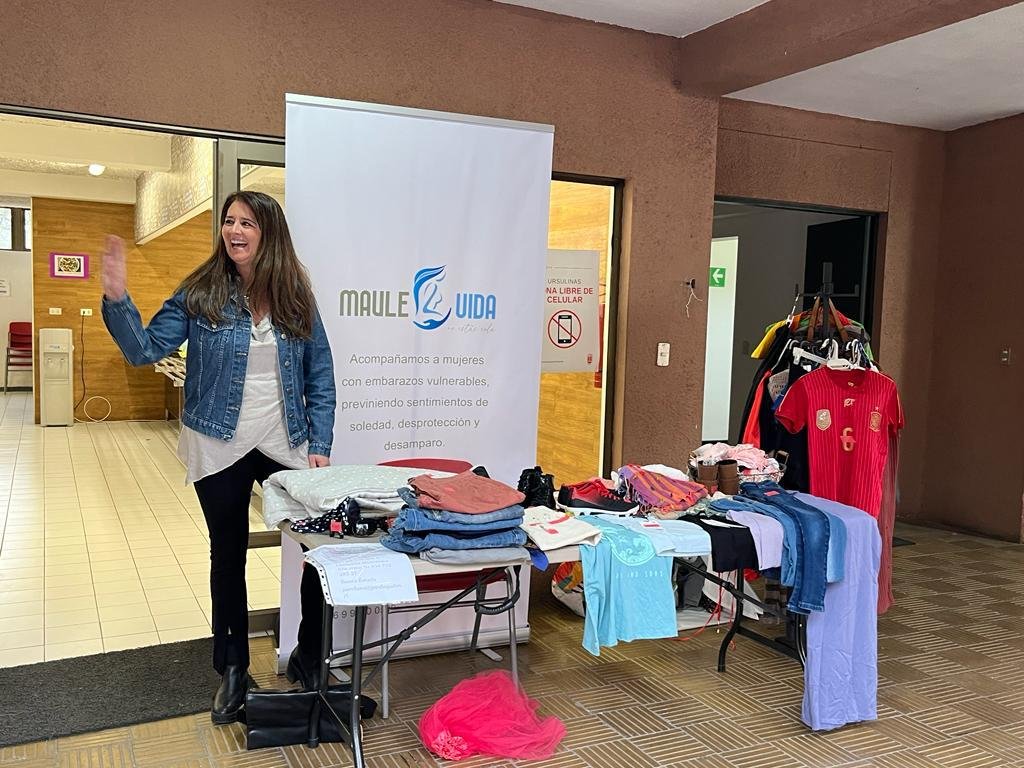 Mesa con ropa y artículos para bebé en una actividad de MauleVida