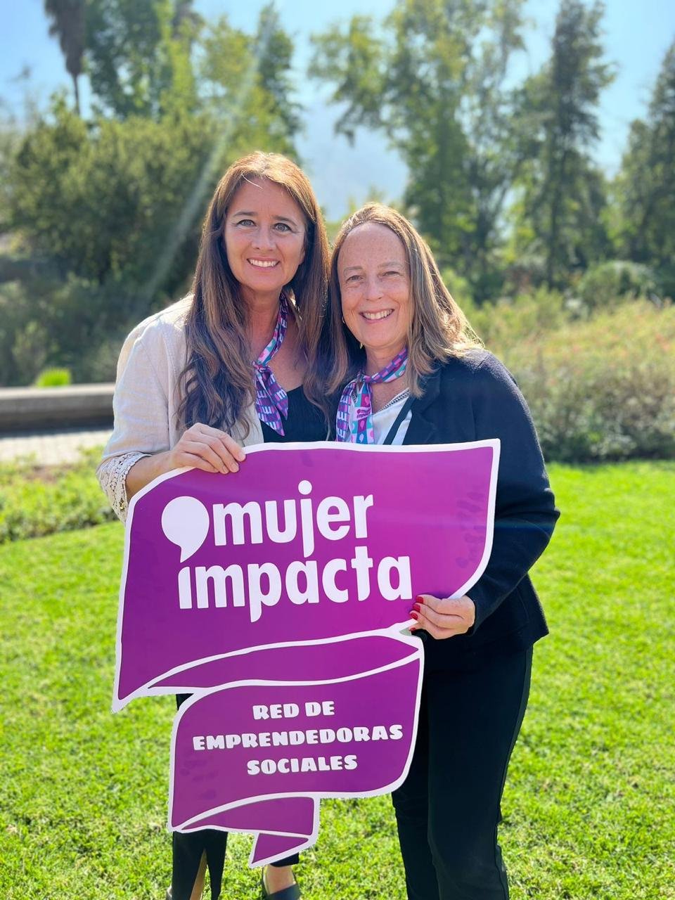 Dos integrantes de MauleVida junto a un cartel de la red REDMAD